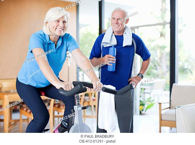 Older woman riding exercise bike at home