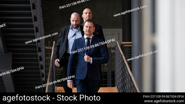 08 November 2023, Saxony, Dresden: Michael Kretschmer (CDU), Minister-President of Saxony, arrives at the plenary chamber with his security guards before the...