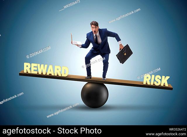 Businessman balancing between reward and risk business concept