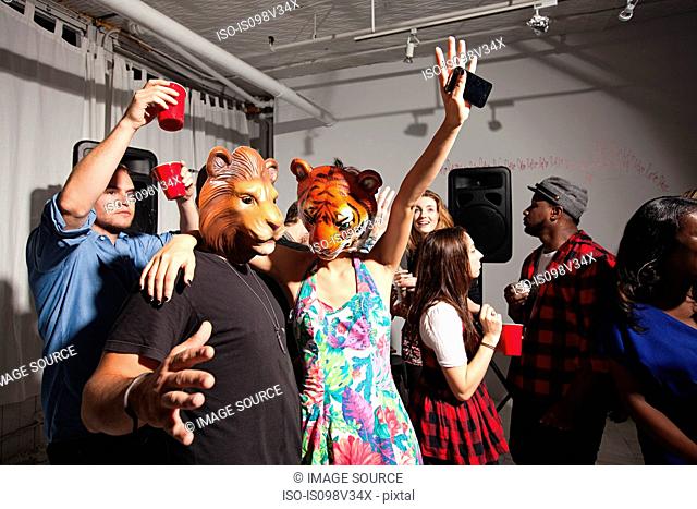 People wearing lion and tiger masks dancing at party