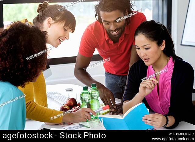 Caucasian businesswoman explaining business plan to male and female colleagues in office