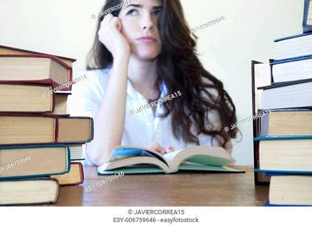Young woman studying with a lot of books