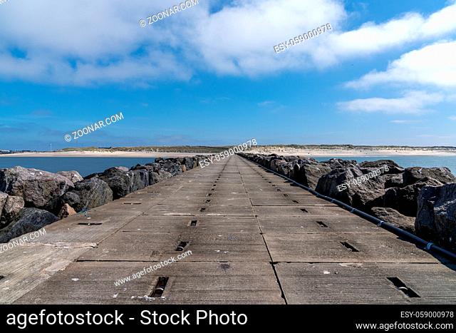 View of long rocky and concrete storm groin jetty to protect against erosion on the Wadden Sea coast of western Denmark