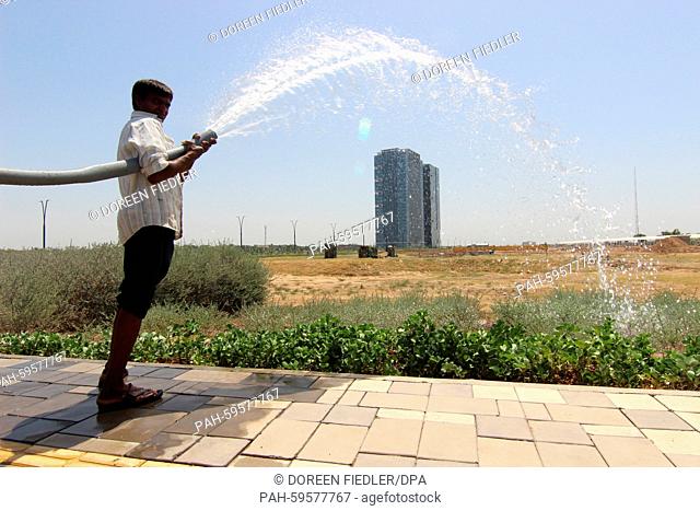A gardener waters the plants in the satellite town GIFT City (Gujarat International Finance Tec-City) in Gandhinagar, India, 16 May 2015