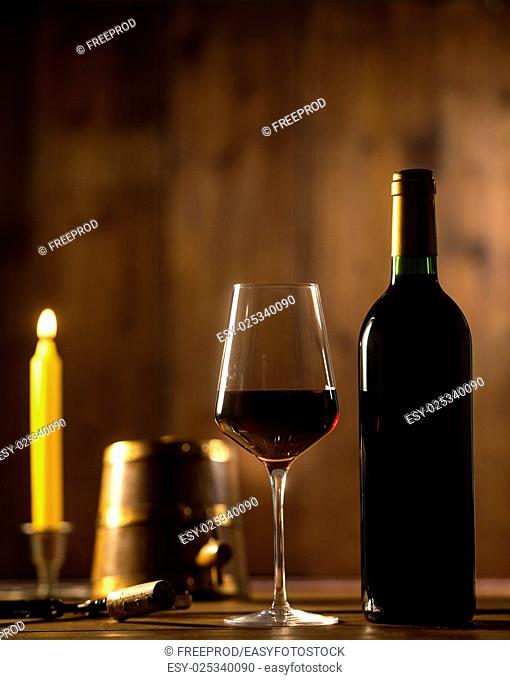 Pouring red wine into wineglass from green bottle, brown background