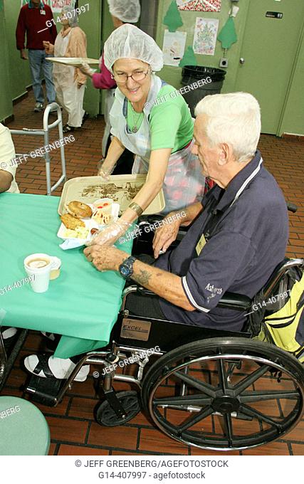 Volunteer server, wheelchair. Christmas dinner for homeless, Camillus House, Miami, Florida. USA