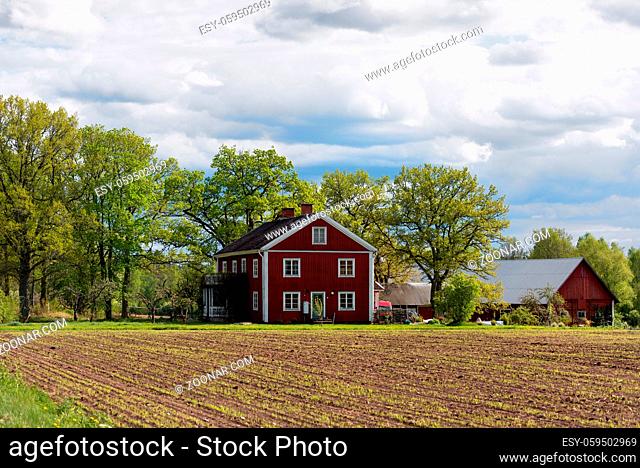 Traditionelles Bauernhaus aus dem 19. Jahrhundert in Småland, Schweden an einem Frühlingstag. Red wooden house in Sweden