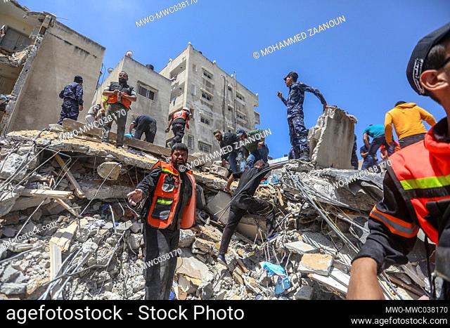 Firefighters and People search for victims of an Israeli airstrike in Gaza City, Gaza Strip