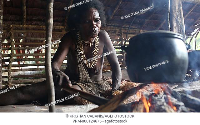 Woman from the Kombai tribe sitting at the fire place, Papua, Indonesia, Southeast Asia