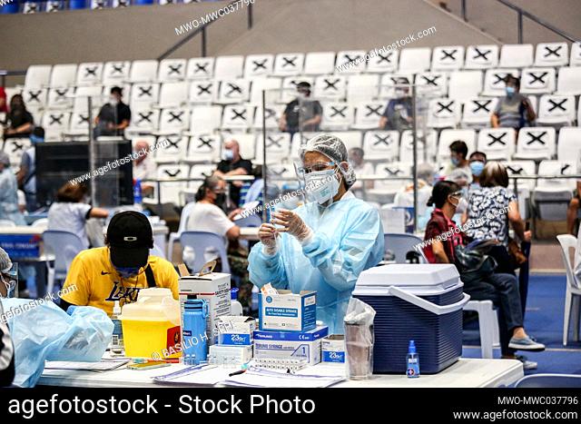 Health workers inoculate residents with the Russian-made Sputnik V COVID-19 vaccine, at the Makati Coliseum in Metropolitan Manila