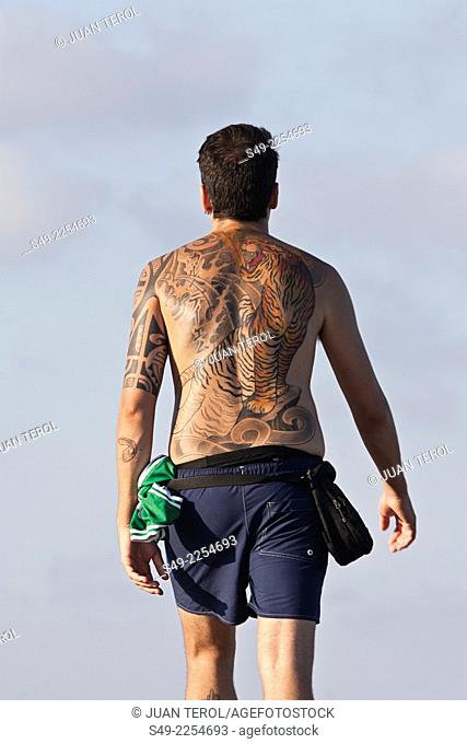 Man wearing a big and colorful tattoo on his back