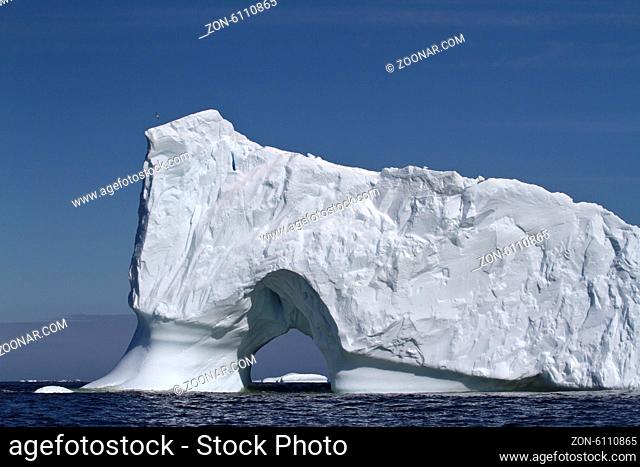 Iceberg with large through the entrance to the ocean off the coast of the Antarctic Peninsula