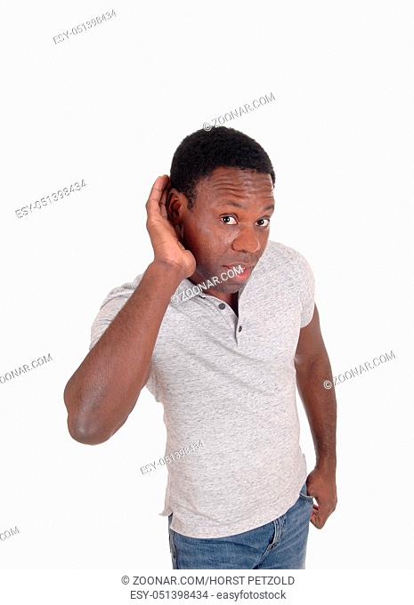 A young African American man in a gray t-shirt with his hand on his ear whit a hearing problem, isolated for white background