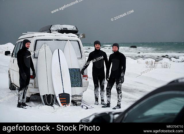 Authentic local Arctic surfers in wetsuit after surfing in Norwegian sea by minivan. Scandinavian Lofoten islands