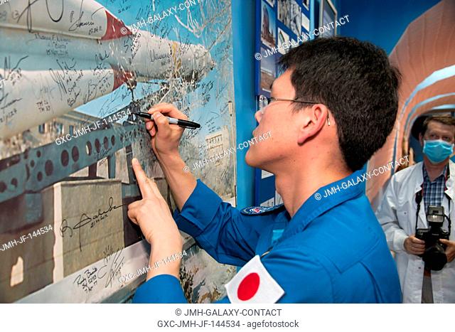 Expedition 52-53 backup crewmember Norishige Kanai of the Japan Aerospace Exploration Agency (JAXA) signs a mural in a space museum in Baikonur