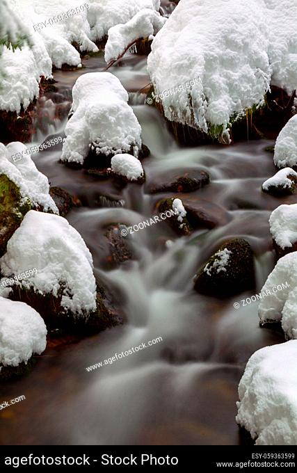 Langzeitbelichtung eines Bachs im verschneiten Bayrischen Wald, Bayern, Deutschland. Long exposure of the Kleine Ohe, a small creek flowing through the snowy...