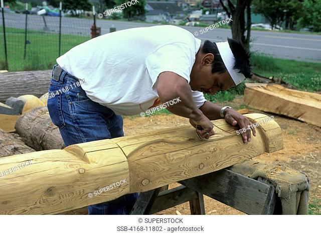 USA, Washington, Near La Conner, Swinomish Indian Reservation, Native American Wood Carver Kevin Paul Working On Totem Pole