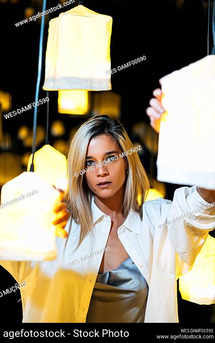 Beautiful woman standing in middle of electric lamp