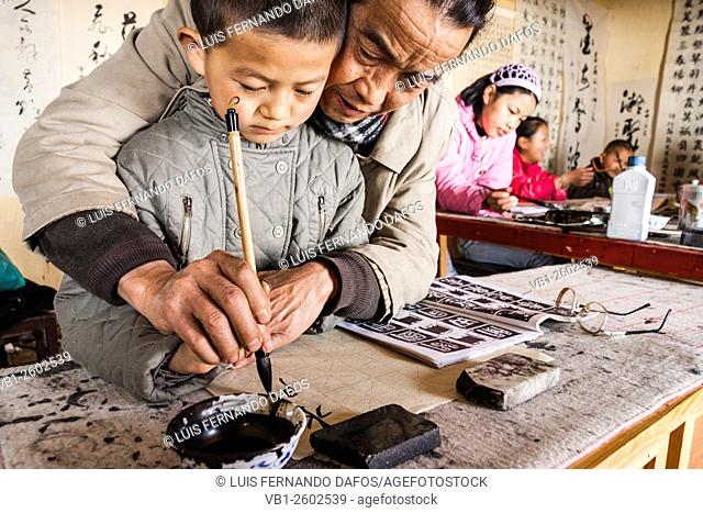 Teacher and pupil at traditional calligraphy school. Lijiang, China