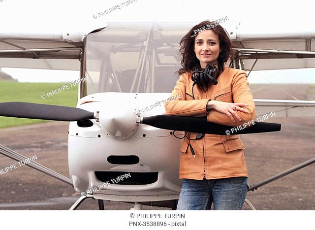 Pilot young woman standing in front of her microlight