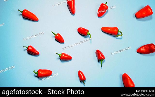 Multiple mini red bell peppers beautifully laid out and ready to eat isolated on sky blue background