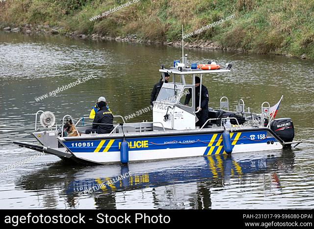 17 October 2023, Saxony, Bad Schandau: Czech police officers ride on a boat on the Elbe River during an exercise with a German shepherd dog