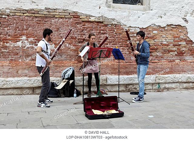 Italy, Venetto, Venice. Music students busking in the Accademia district of Venice