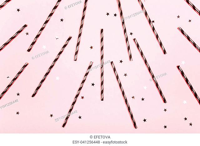 Festive background made of and cocktail tubes and little stars, flat lay. Pink trend background with little silver stars on it