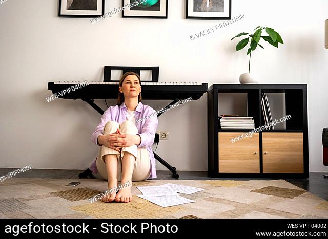Tired woman leaning on piano at home