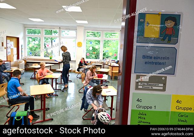10 June 2020, Hessen, Wiesbaden: A sign with the inscription ""Please enter individually"" is placed next to the classroom of the 4C of the...