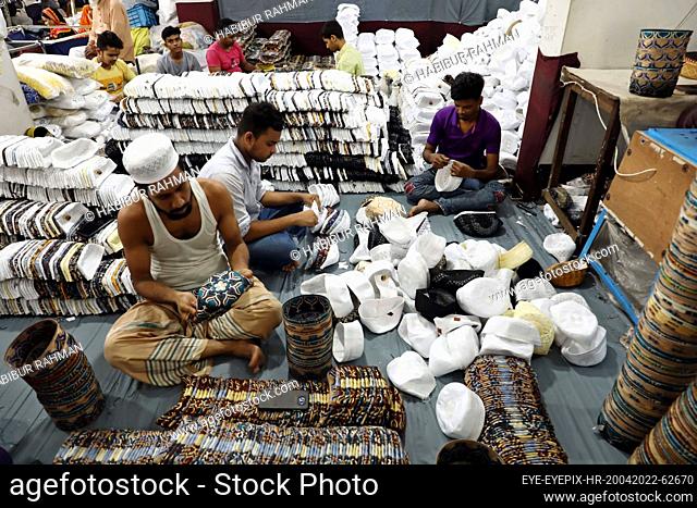 DHAKA, BANGLADESH - APRIL 23, 2022: Employees are seen work during the production of hats inside a factory ahead of Eid-ul-Fitr at a factory in Dhaka