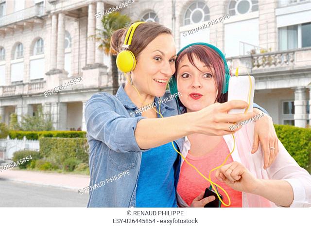 Two young women with headphones taking a selfie