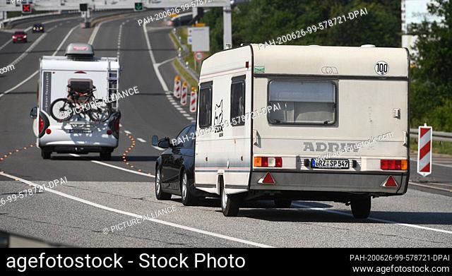 26 June 2020, Mecklenburg-Western Pomerania, Stralsund: Motorhomes and cars with trailers drive over the Rügenbücke to the island of Rügen