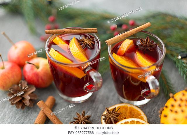 glass of hot mulled wine, cookies, apples and fir