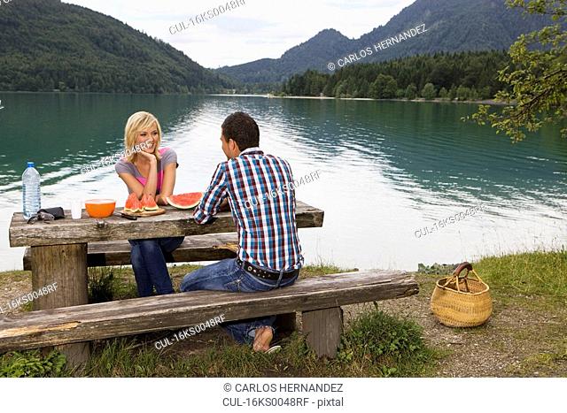 A young couple having a picnic by a lake