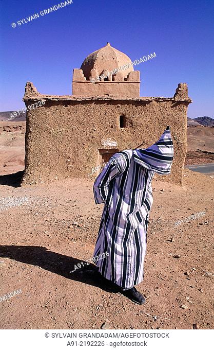 MOROCCO.SOUTH.OUARZAZATE.OLD MAN CLOSE TO AN ADOBE ""MARABOUT"" (MEANS A VAULTED HOLY MAN GRAVE SUBJECT TO PILGRIMAGES AND FAITH)