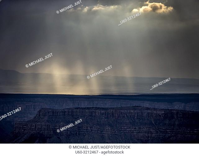 Storm clouds pass over the Grand Canyon and produce sunbeams near Timp Point, Kaibab National Forest, Arizona
