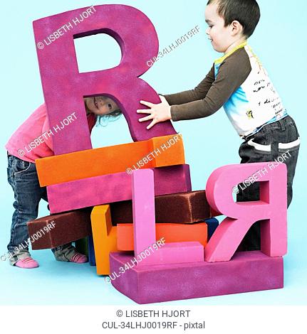 Toddlers playing with oversize letters