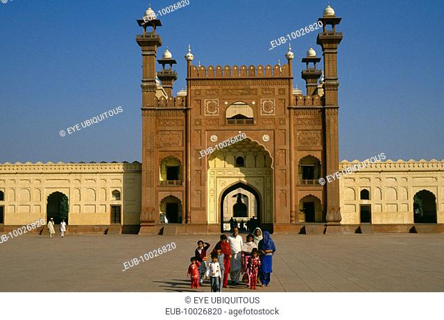 Badshahi mosque. Family standing in courtyard outside entrance of mosque attached to the Royal Fort built c. 1673 during reign of the Mughal emperor Aurangzeb