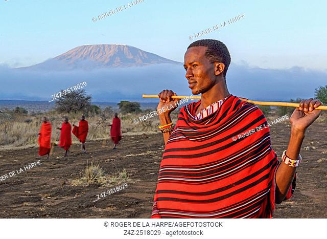 Maasai (Masai) elders with Mount (Mt) Kilimanjaro in the background. Satao Elerai Conservancy. Near Amboseli National Park. Kenya