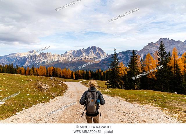 Rear view of female hiker hiking at Dolomites Alps, Cortina, Italy