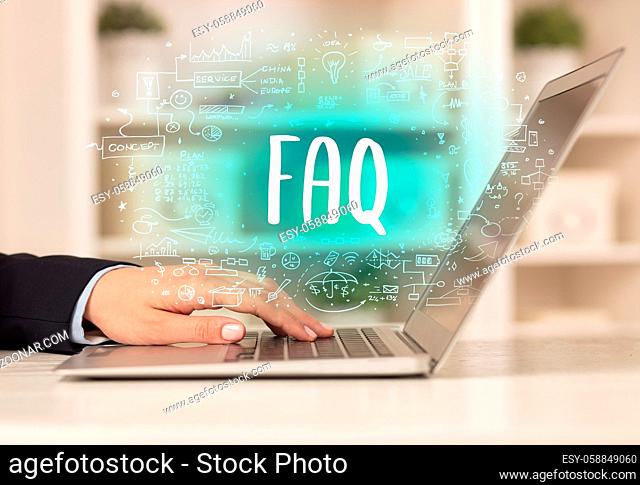 hand working on new modern computer with FAQ abbreviation, modern technology concept