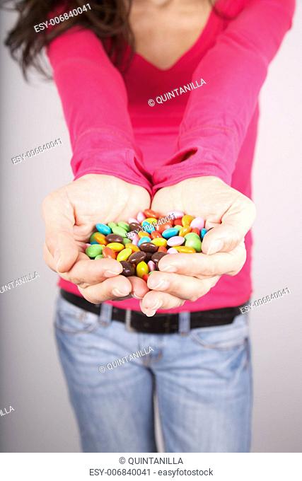 woman portrait holding lot of candy in her hands