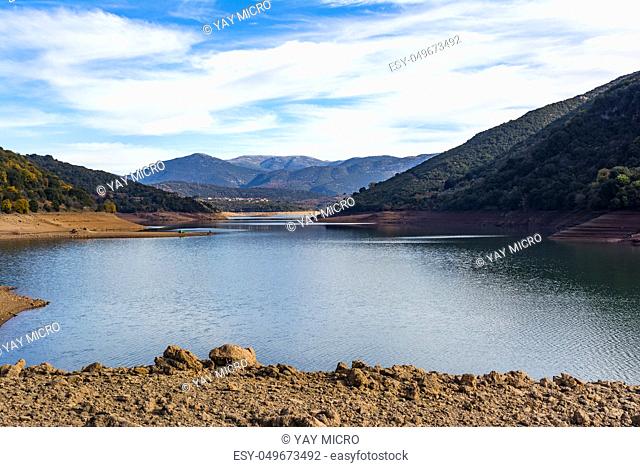 Ladonas artificial lake in Arcadia, Greece against a blue sky with clouds, and mountains as background