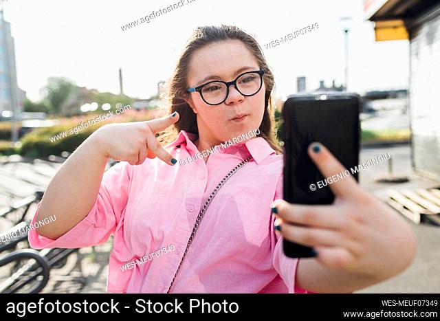 Teenager puckering and taking selfie on smart phone
