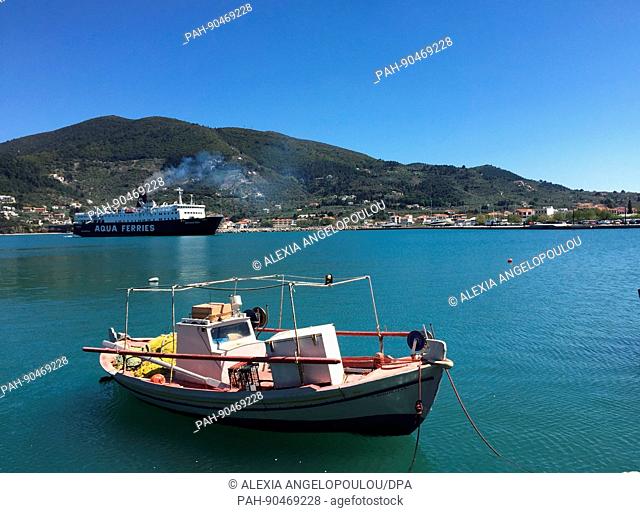 A fishing boat and a ferry near the harbour on the island of Skopelos, Greece, 18 April 2017. Locals are hoping that this summer brings a greater number of...