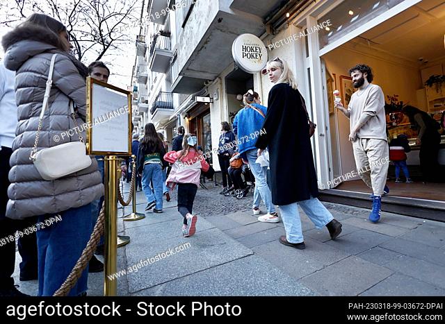 18 March 2023, Berlin: A customer comes out of the ice cream parlor ""Hokey Pokey"" in Prenzlauer Berg with an ice cream cone