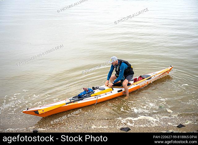 27 June 2022, Lower Saxony, Greetsiel: Frank Feldhus and his kayak companion Mazzo are at the East Frisian Ley Bay in the North Sea
