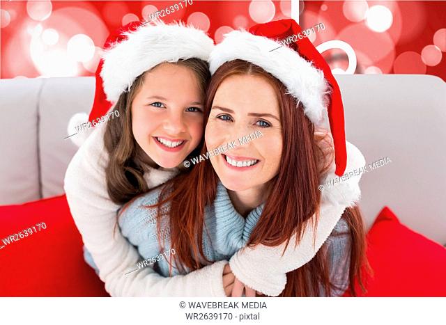 Happy mother and daughter in santa claus hats