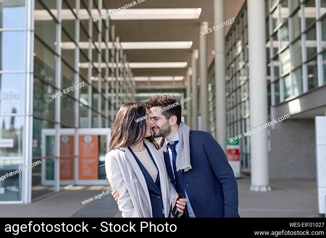 Business couple smiling while standing together